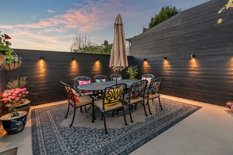 Private patio with dining furniture and evening lighting