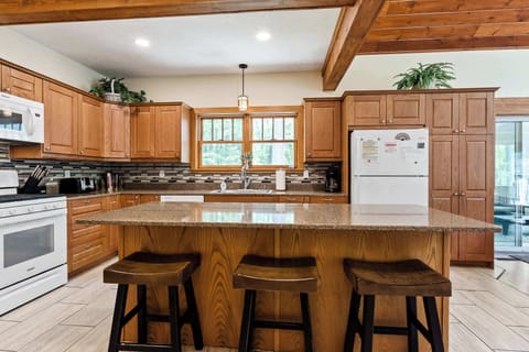 Scott Creek Lodge kitchen with island seating. Behind you - half bathroom; to the right - living room with fireplace & lots of lounge seating.