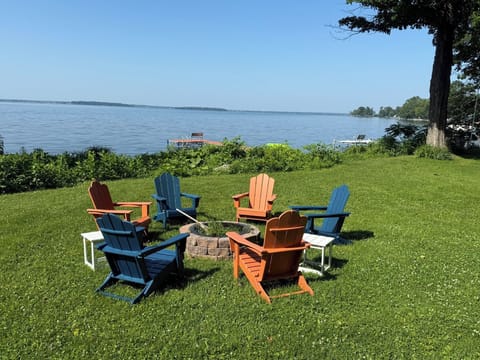 Fire pit with Adirondack chairs and tables for s'mores. 