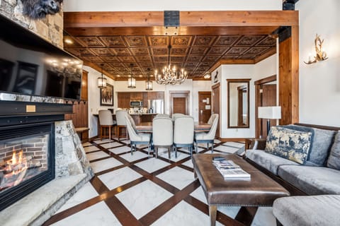 Great room — stone hearth, antler chandelier, slopeside light.
