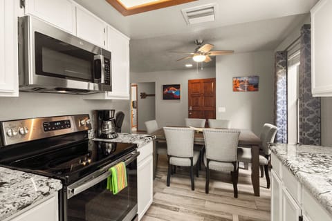 Modern kitchen and dining area with granite countertops, stylish seating, and a welcoming feel.