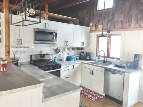 The fully-stocked kitchen has all brand-new appliances including a gas grill, microwave, fridge and dishwasher. Coffee pot, Kurig, waffle-maker and toaster included.