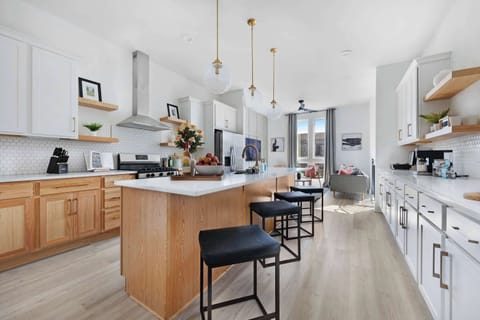 Fully equipped kitchen with a spacious pantry and a large island with five barstools, perfect for meal prep and casual dining.