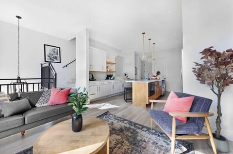 Stylish living room featuring a wall-mounted smart TV, a sleek leather couch, a modern coffee table, and three elegant accent chairs for a cozy and inviting ambiance.