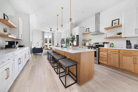 Modern kitchen with a spacious pantry and a large island with five barstools, ideal for cooking and casual dining