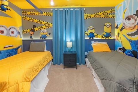 Experience a fun-filled bedroom with two cozy beds in vibrant bedding. Cheerful yellow walls and colorful Minion artwork create an energetic vibe, making this a delightful retreat for guests of all ages.