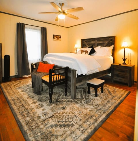 Primary bedroom, complete with luxurious bedding, TV and Fan