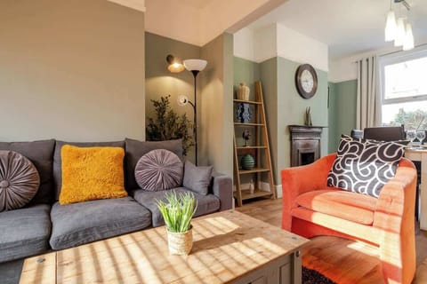 Comfort meets convenience in the living room, complete with a soft sofa, armchair, and a large TV to enjoy your favourite shows