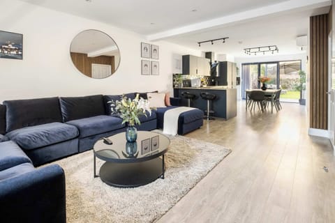 Living Room | Elevated comfort in a spacious air conditioned living area with 70 Inch TV and an open plan kitchen leading to a private garden, complete with a PS5 for relaxed entertainment, creating the perfect setting to enjoy your holiday in style.