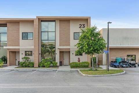 Step into a contemporary exterior featuring large windows that invite natural light, accented by lush greenery around the entrance. With a clean façade and a welcoming atmosphere, this home sets the stage for a delightful stay.