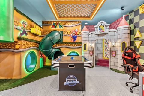 Enter a lively game room filled with colorful murals and playful design. Enjoy the bright green slide and castle play area for endless fun, while the sleek game table invites friendly competition among guests.