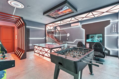 Discover a lively game room with a stylish foosball table and cozy modern seating. Neon accents light up the space, setting the perfect vibe for friendly competitions or laid-back evenings with friends.
