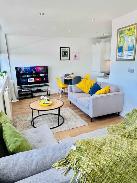 Bright and airy living room with comfortable seating, smart TV and vibrant pops of colour throughout