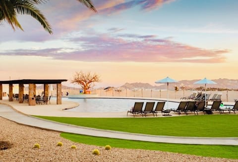 Poolside loungers, umbrellas, bathrooms, shower, and pergola for dining.