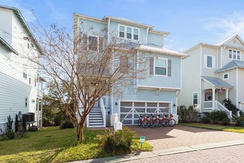 Charming coastal home with bright exterior and convenient bike storage for exploring the neighborhood.
