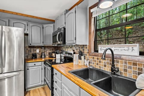 This stylish kitchen blends modern appliances with rustic charm, featuring butcher block countertops and warm wood tones for a homey, inviting feel.