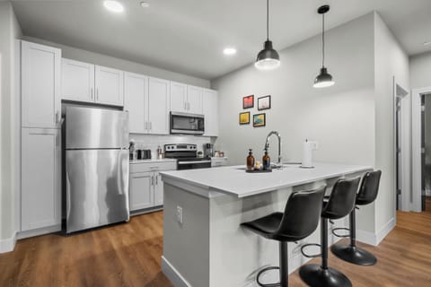 The fully equipped kitchen features sleek, modern appliances and ample counter space, making it easy to prepare your favorite meals or a simple cup of coffee!