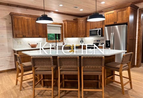 A thoughtfully designed kitchen with rich wood tones, a large island, and modern appliances makes cooking a pleasure.