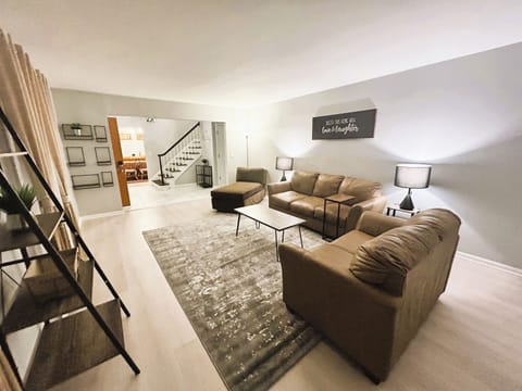 Spacious living room featuring three comfortable sofas, perfect for gatherings.