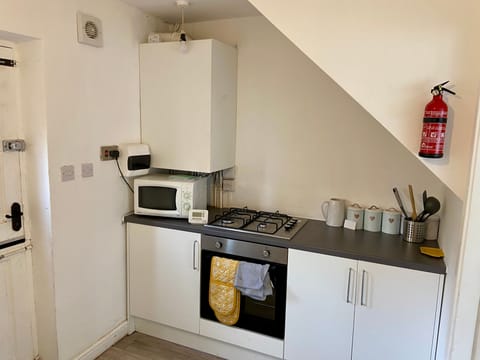 Kitchen with microwave, single cooker and gas hob.