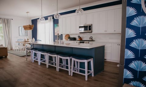 A chef’s dream with a coastal twist. Enjoy a fully stocked kitchen complete with premium appliances and a large island that doubles as the heart of the home.