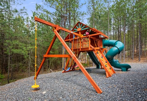 This awesome playset is a kid’s dream come true—complete with swings, a slide, climbing features, and tons of space to run around beneath the trees.