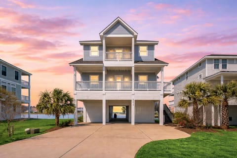 Stunning exterior of luxury Galveston beach house with spacious driveway, coastal architecture, and elevated design—perfect vacation rental near the water.