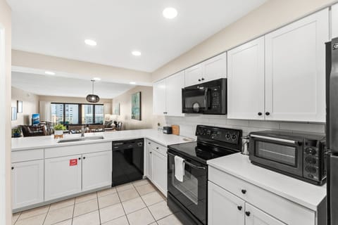 Kitchen with appliances includes microwave oven, stove, blender, coffee maker and toaster