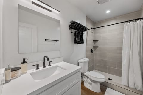 This stunning renovated bathroom boasts a walk-in shower, complete with a vanity with ideal lighting to elevate your morning routines