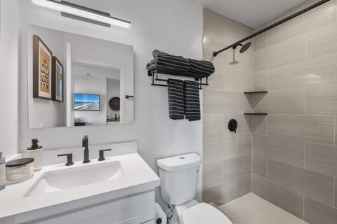 This stunning renovated bathroom boasts a walk-in shower, complete with a vanity with ideal lighting to elevate your morning routines