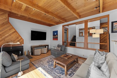 Your open-plan living space glows beneath vaulted wood ceilings. Sink into plush seating, enjoy the warmth of your fireplace, and unwind while watching your favorite shows on the flat-screen TV.