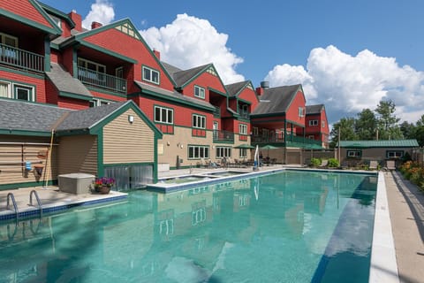 Dive into relaxation with a refreshing swim, surrounded by stunning mountain architecture and blue skies.