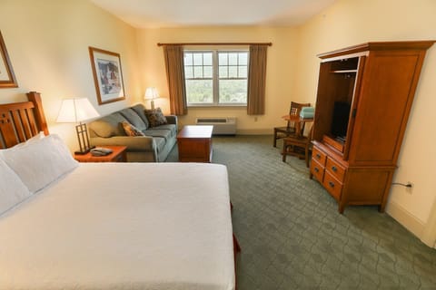 Room with plush bed and comfortable seating area, perfect for relaxing.