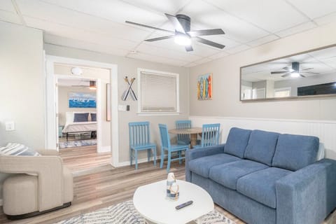 Coastal charm meets comfort in this breezy living space, complete with a plush sofa, beach-inspired accents, and a cozy dining nook perfect for relaxed meals or game nights.