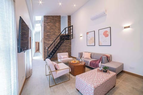 Living room, stairs are used to access mini bedroom on mezzanine.