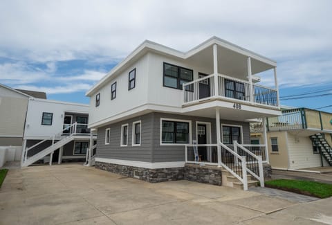Freshly updated coastal property with private unit entrances, a clean modern façade, and spacious driveway access. Located just a short walk from the beach, perfect for group getaways or family stays. (Character count:
