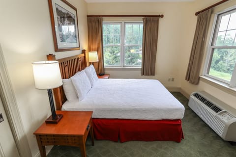 Comfortable bedroom with a spacious bed and large windows offering natural light.