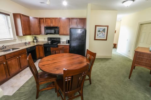Well-equipped kitchen with rich wood cabinetry and a welcoming dining space, ideal for home-cooked meals.