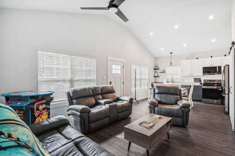 Living room with vaulted ceiling, arcade game, open floor plan