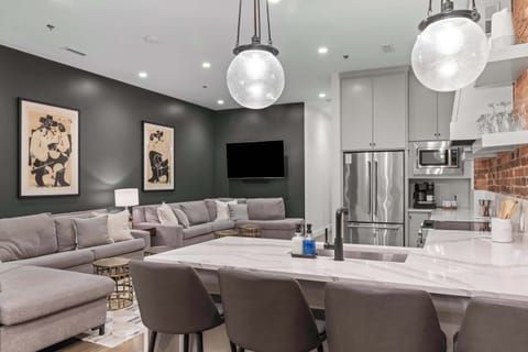 Bright and spacious kitchen with white cabinetry, open shelving, and a long island that seats four. Perfectly designed for cooking, hosting, and gathering.