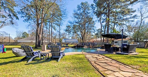 Backyard oasis with pool, lounge areas, and serene view