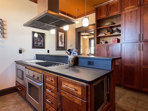 Custom designed kitchen with granite island and island seating to enjoy family cooking with all the extra kitchen amenities at Tamm Loft.