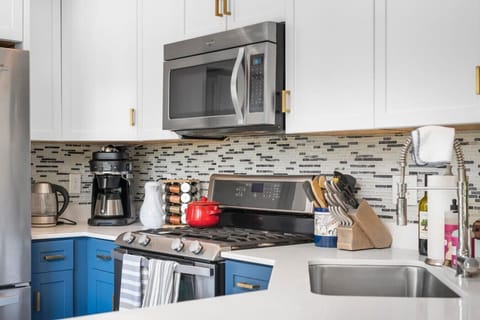 Kitchen features stainless steel appliances + coffee maker