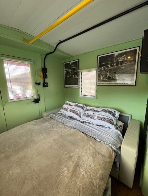 Bed is a cozy queen pull out couch, with linens, 2 pillows, and quilt