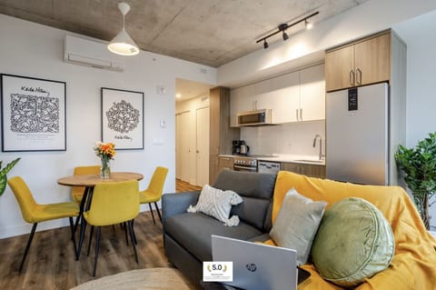 Living Room: Pops of yellow and soft neutrals brighten this cozy open-concept space