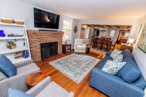 Comfortable and cozy living room with fireplace (for aesthetic only), Smart TV, comfortable seating, games/puzzles, and books.