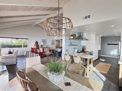 The open layout leads to a dining table for six with endless ocean views. Step onto the patio for al fresco meals, cozy up by the fire table, or grill with sunset skies.