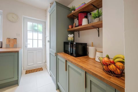 This kitchen includes an oven and hob, microwave, fridge freezer, dishwasher, washer dryer, coffee machine, toaster, and kettle. 