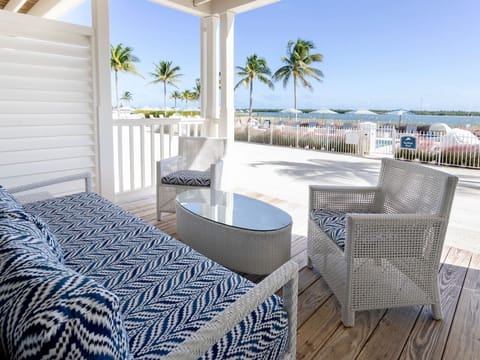 Breezy patio space with stylish seating and serene ocean views, perfect for unwinding under the palms.