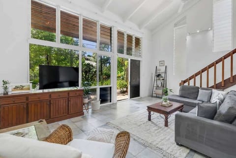 Kick back and relax in the main living area, where lush greenery peeks through the windows, and movie nights on the L-shaped sofa feel like home.